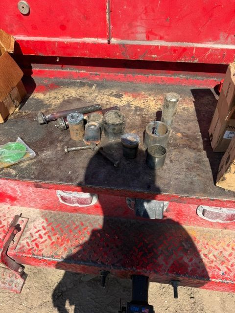 Red tool drawer with dusty sockets and wrenches scattered inside.