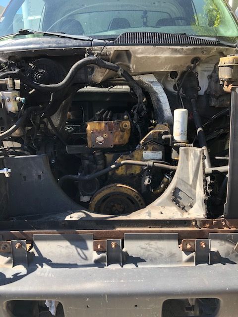 Engine bay of a yellow Caterpillar diesel engine in a vehicle.