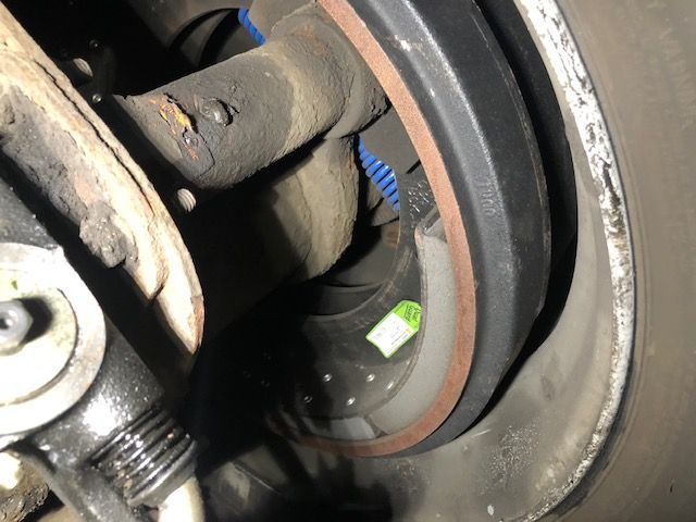 Close-up of a truck's drum brake system, showing the drum, brake shoes, and related components.
