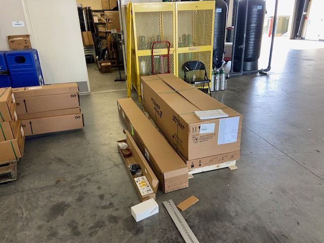 Boxes on a pallet in a warehouse; some boxes are open with contents exposed; industrial setting.
