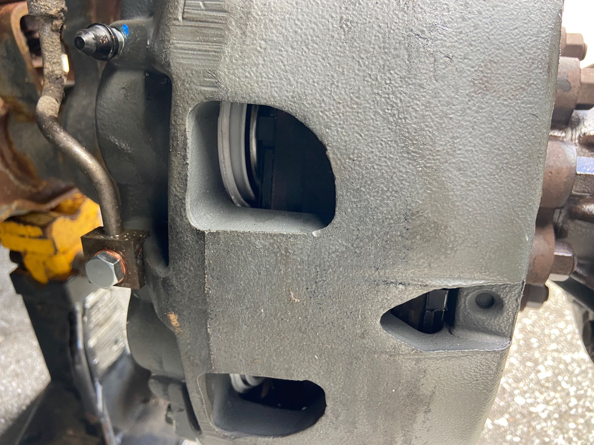 Close-up of a gray truck brake caliper, showing the opening where the brake pad sits.