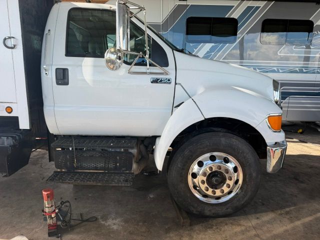 White semi-truck cab parked indoors with a chrome wheel and visible side steps