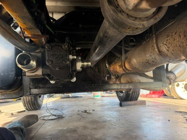 Undercarriage view of a vehicle with exhaust and drivetrain components in a garage lift