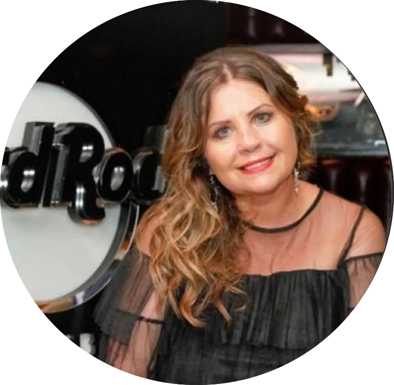 Woman in a sheer black top smiles against a Hard Rock sign background