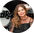 Woman in a sheer black top smiles against a Hard Rock sign background