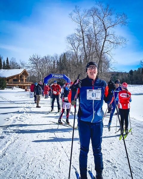 A group of people are cross country skiing in the snow.