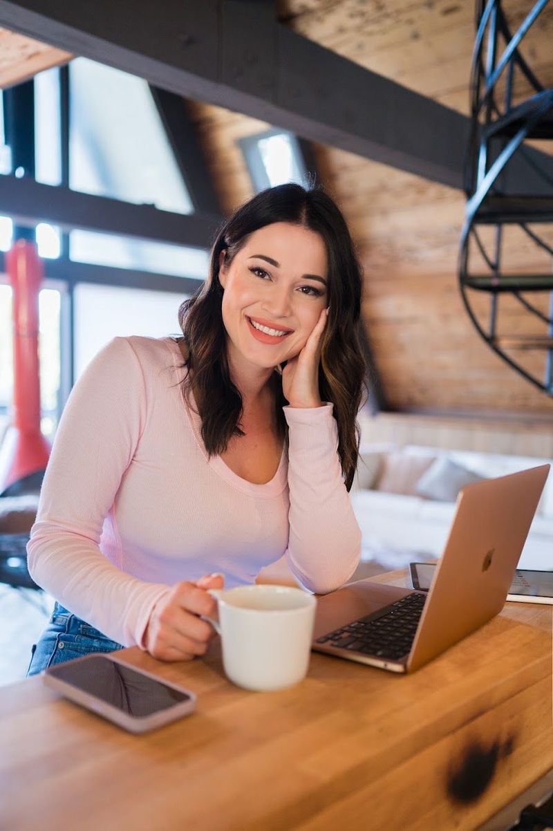 Joy smiling at a wooden counter in an A-frame cabin