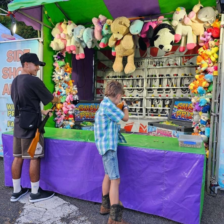 A Man And A Boy Are Playing A Game At A Carnival — Bills Amusements In Rockhampton, QLD