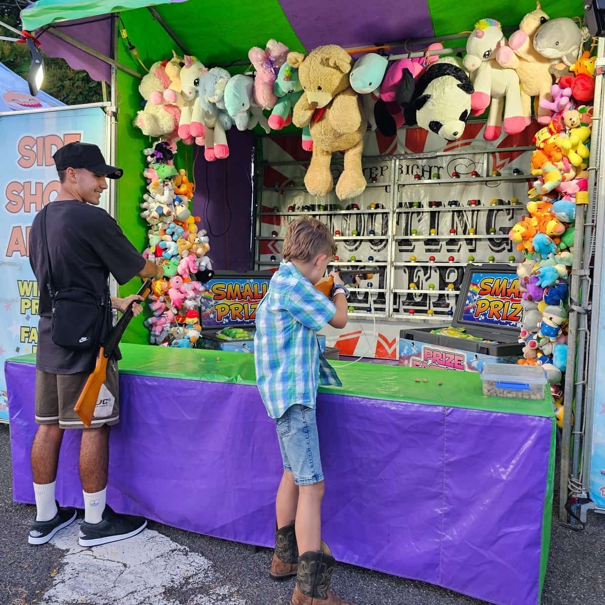 A Man And A Boy Are Playing A Game At A Carnival — Bills Amusements In Hervey Bay, QLD