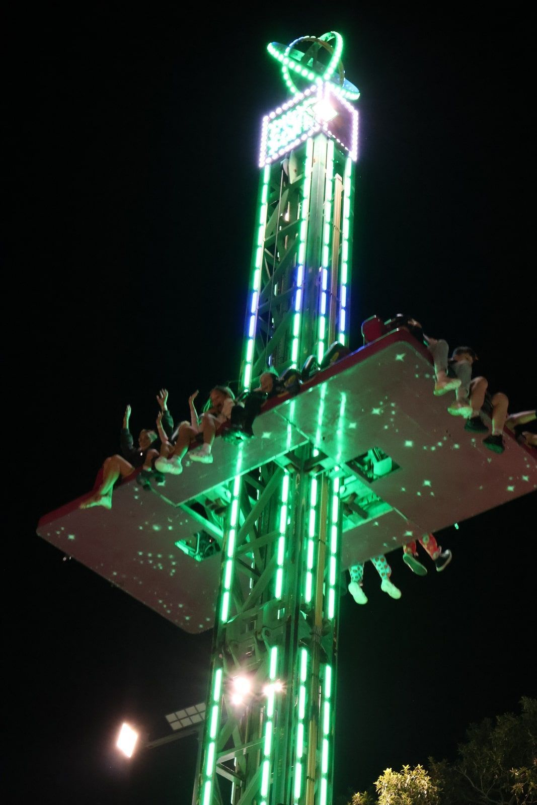 A Group Of People Are Riding A Ferris Wheel At Night — Bills Amusements In Rockhampton, QLD