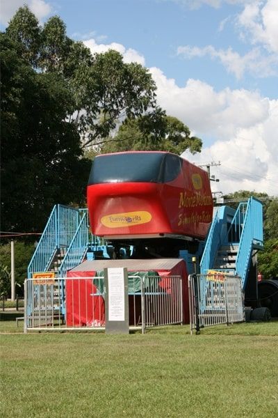 A Red Amusement Park Ride In A Grassy Field — Bills Amusements In Gladstone, QLD