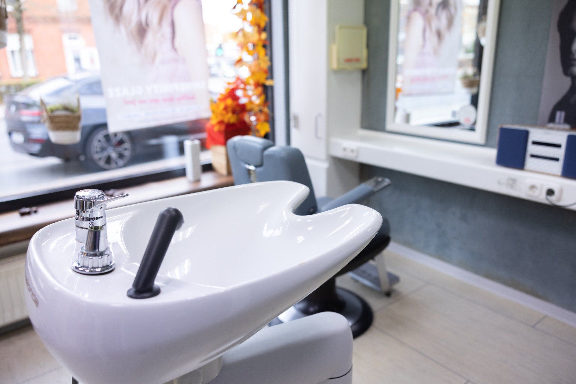 Waschbecken und Stuhl im Salon neben einem Fenster, warten auf eine Haarwäsche.