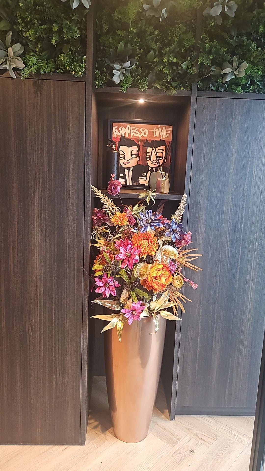 In een hoek van een kamer staat een grote vaas gevuld met bloemen.