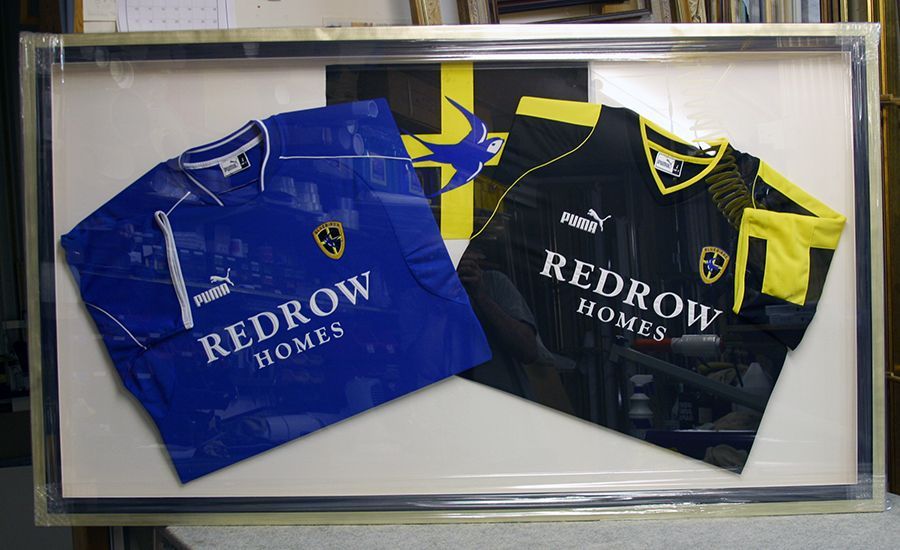 Two shirts and flag framed