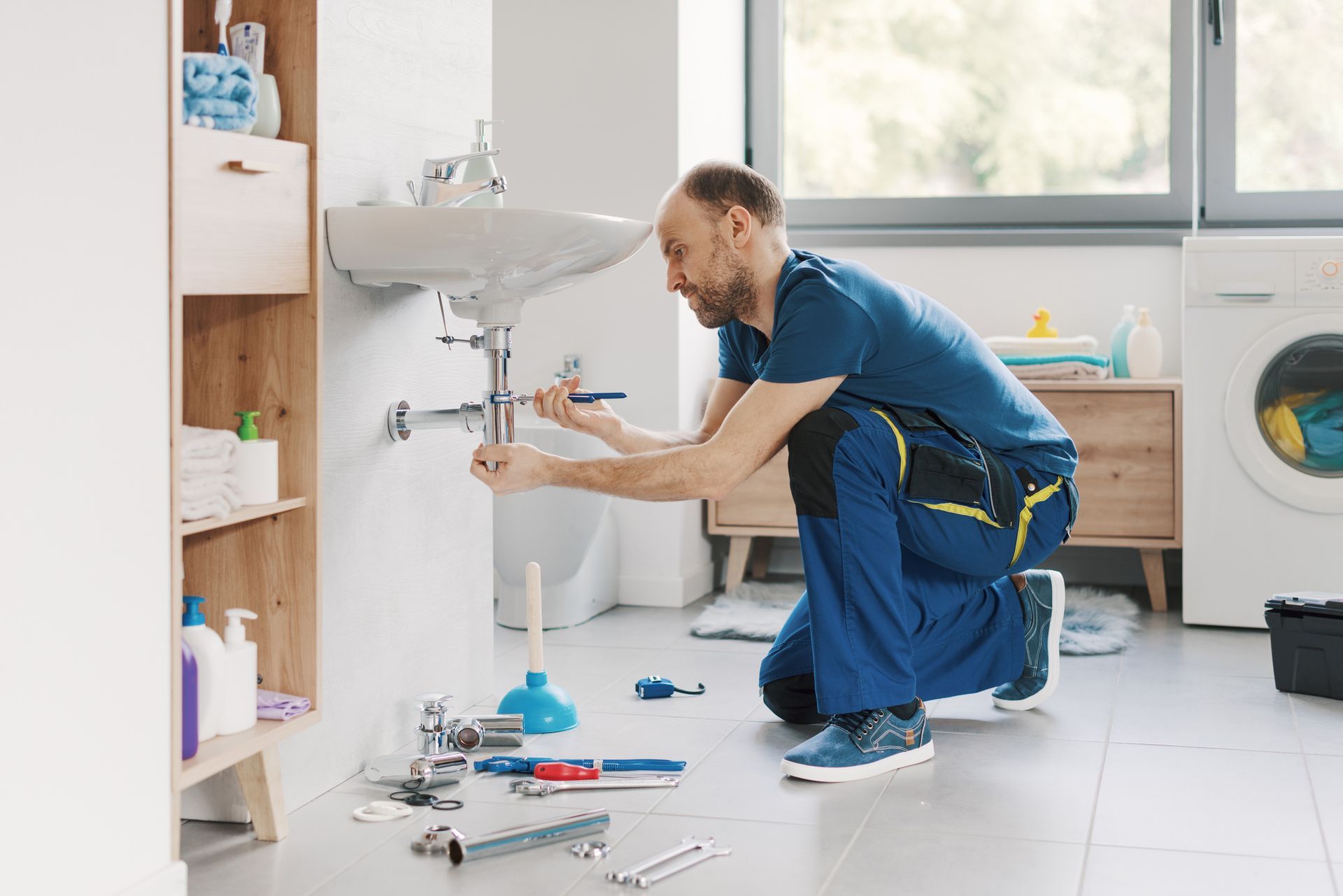Professional plumber repairing a bathroom sink. Professional plumber repairing a bathroom sink.
