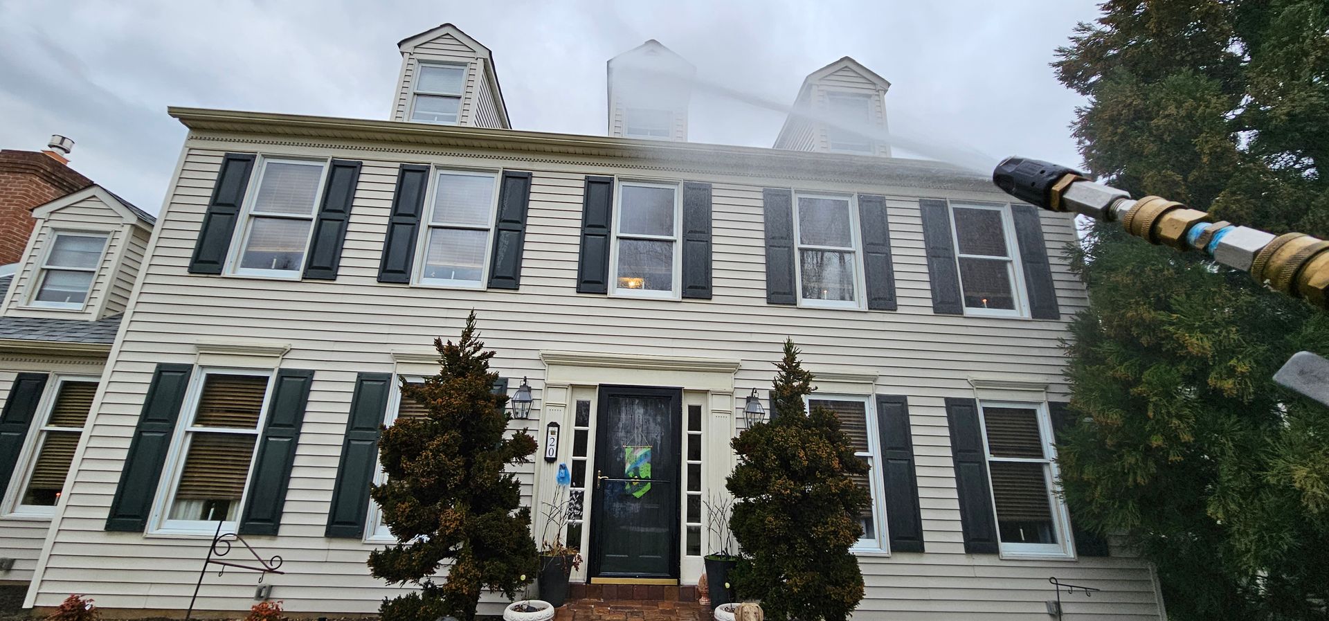 Two-story white house with black shutters and smoke rising from the roof and windows