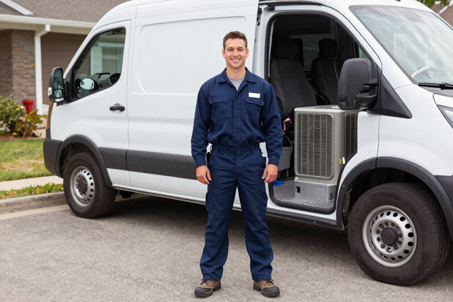 Licensed Clark Heat And Air technician smiling beside a service van in a driveway