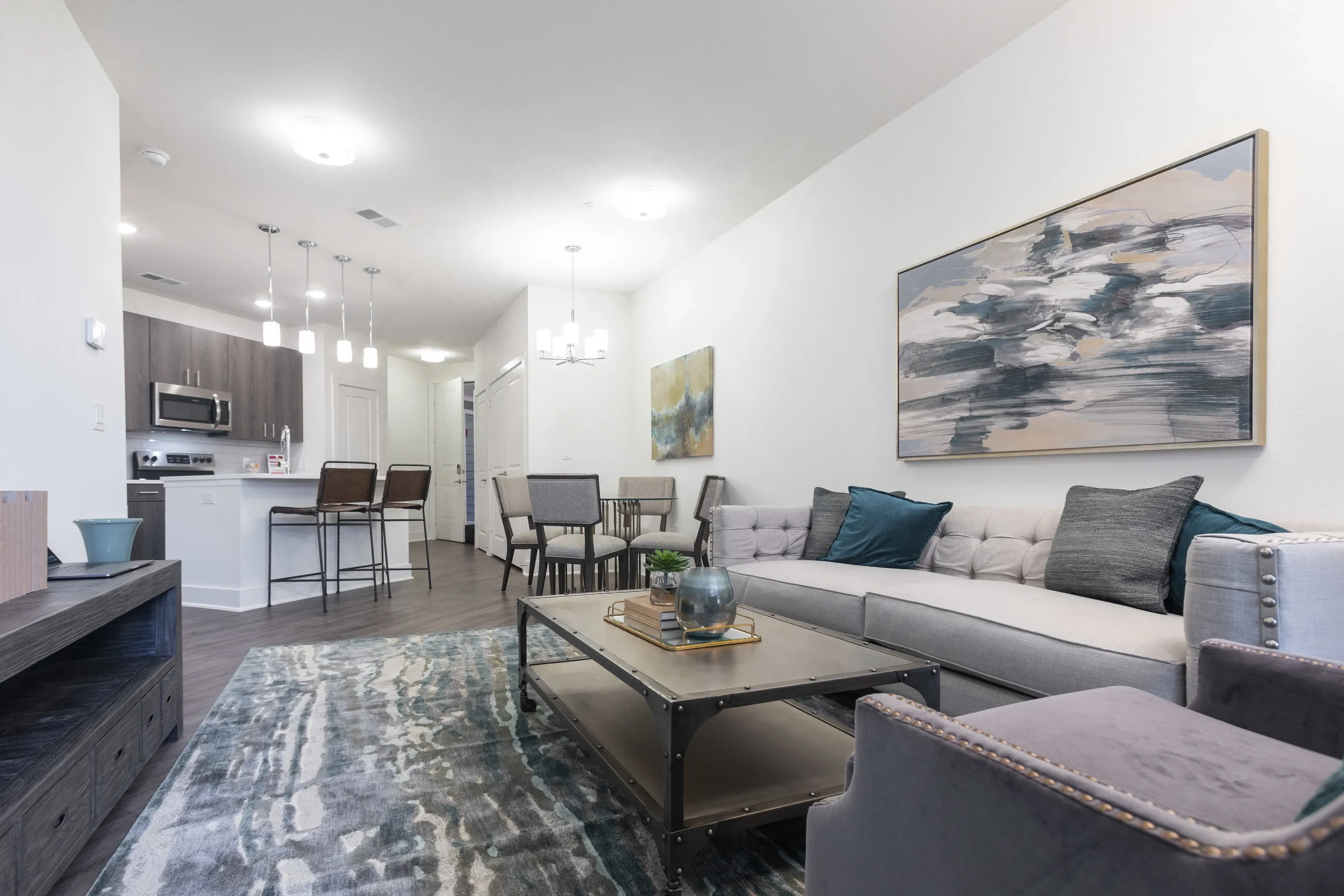 Living room and kitchen area with modern furniture and decor.