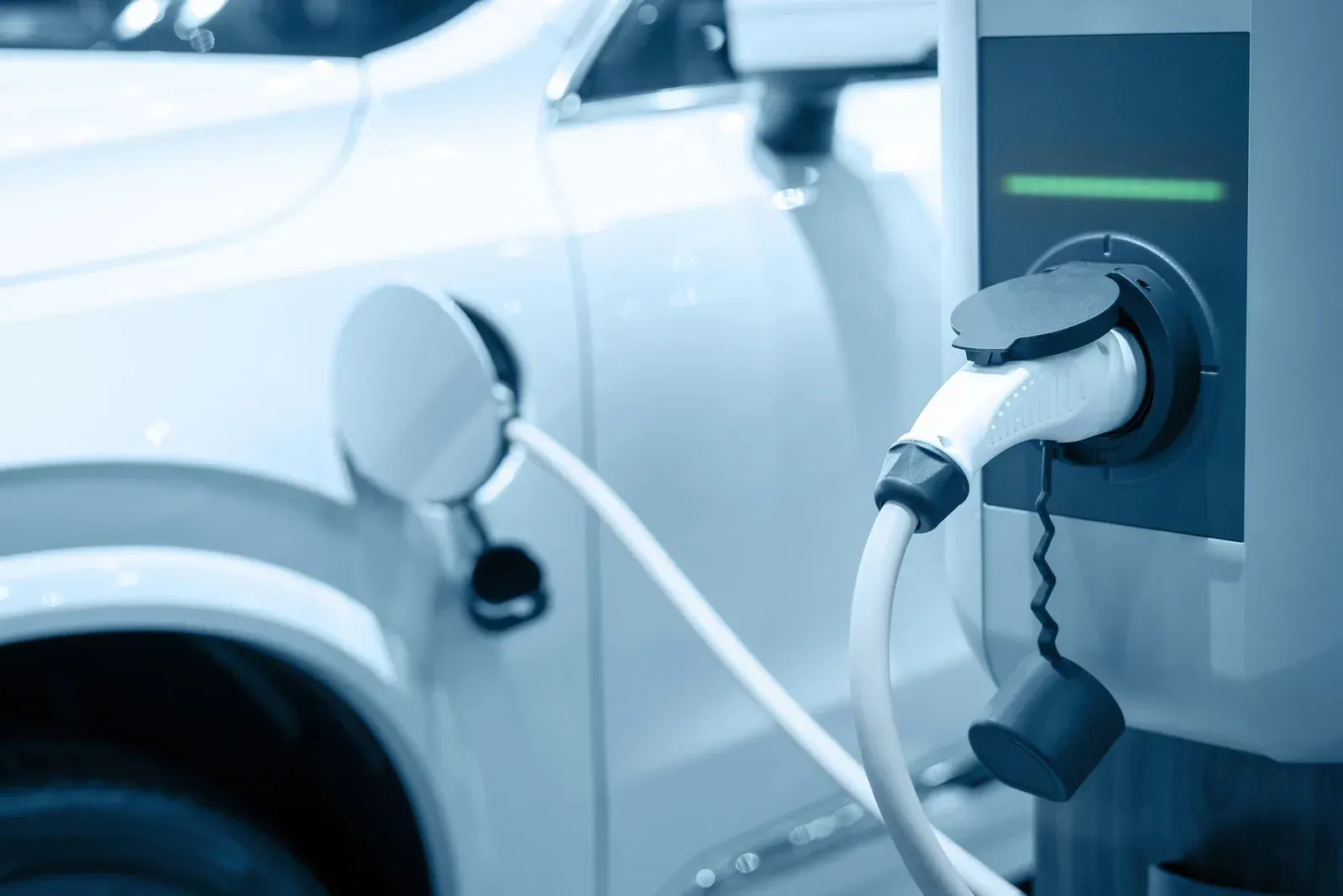 An electric car is being charged at a charging station.