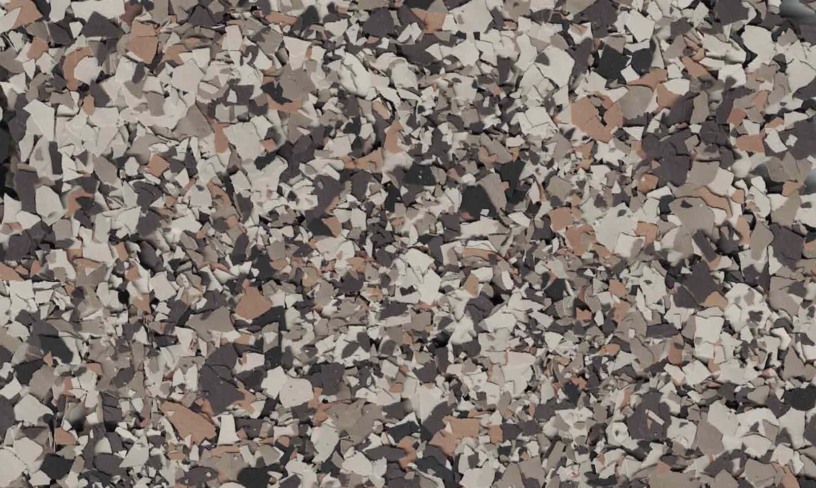 Close-up of a speckled rock or gravel texture in gray, beige, and brown tones.