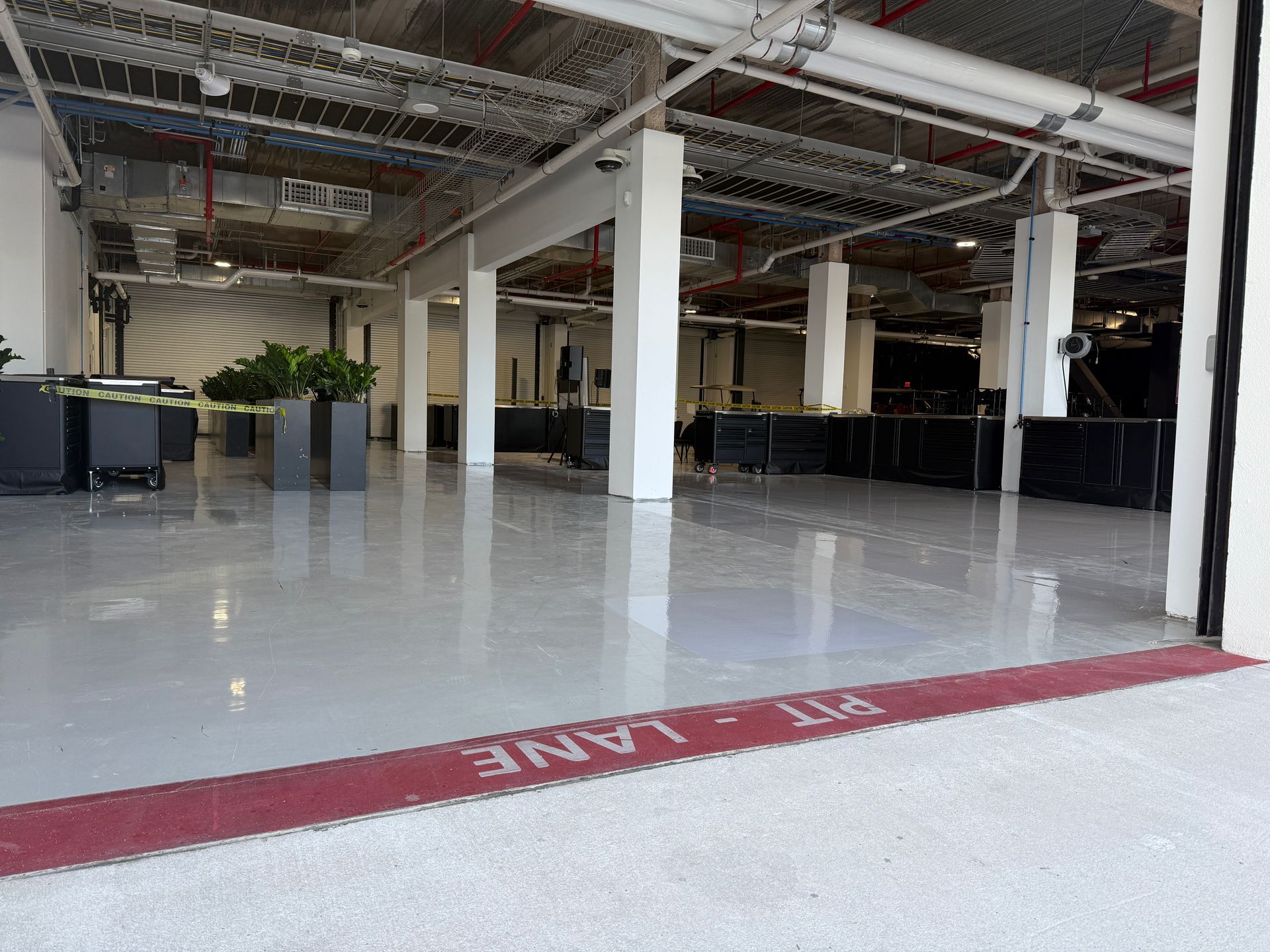 Empty indoor industrial space with polished concrete floor and red floor stripe