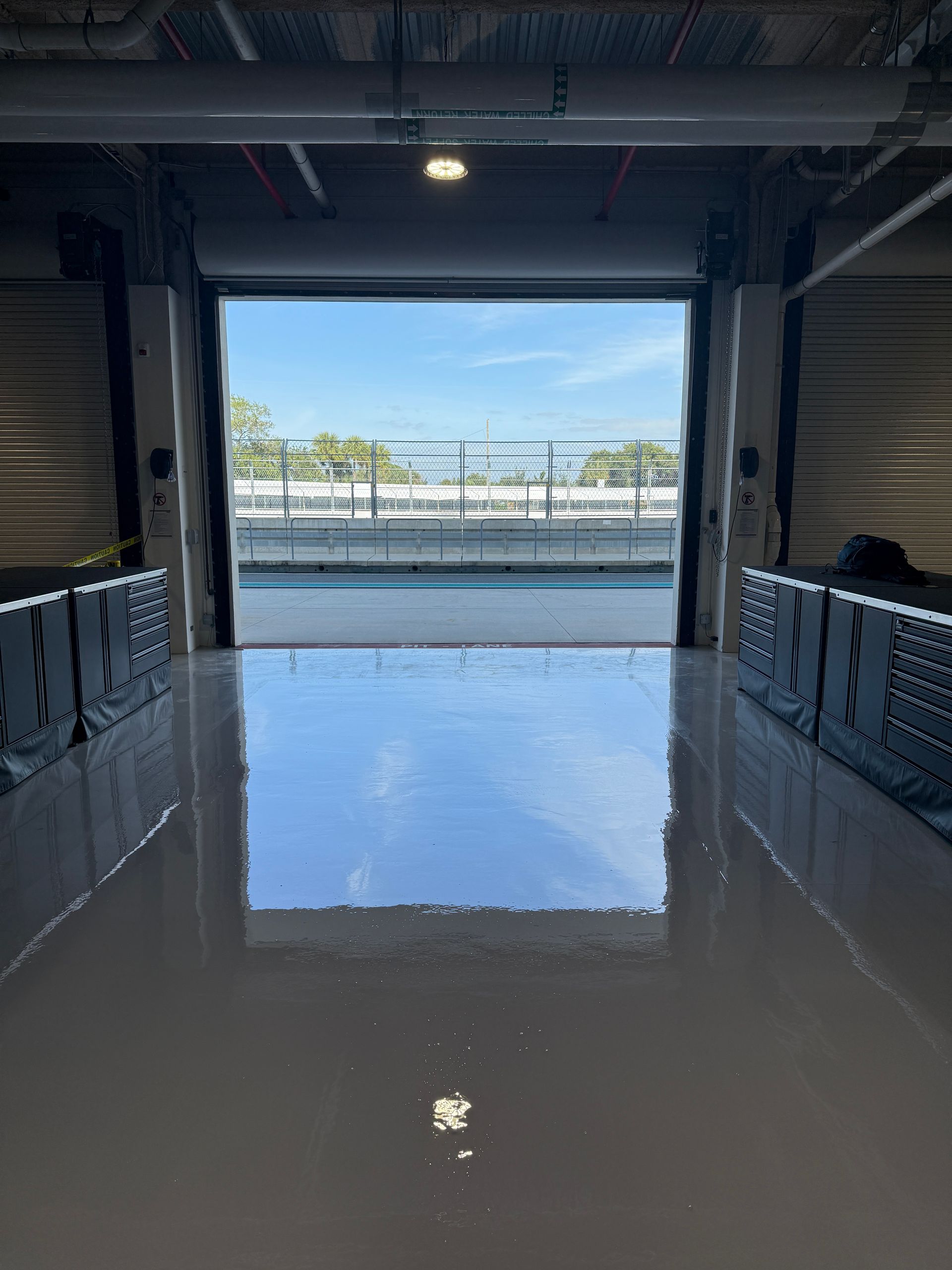 Flooded warehouse interior with a large open doorway and bright outdoor light beyond.