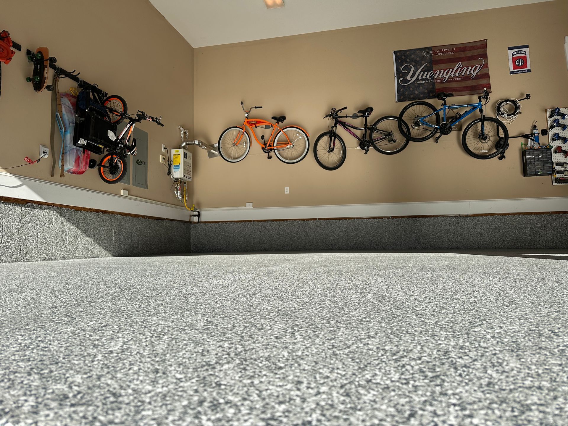 Garage wall with several bicycles hanging above a carpeted floor