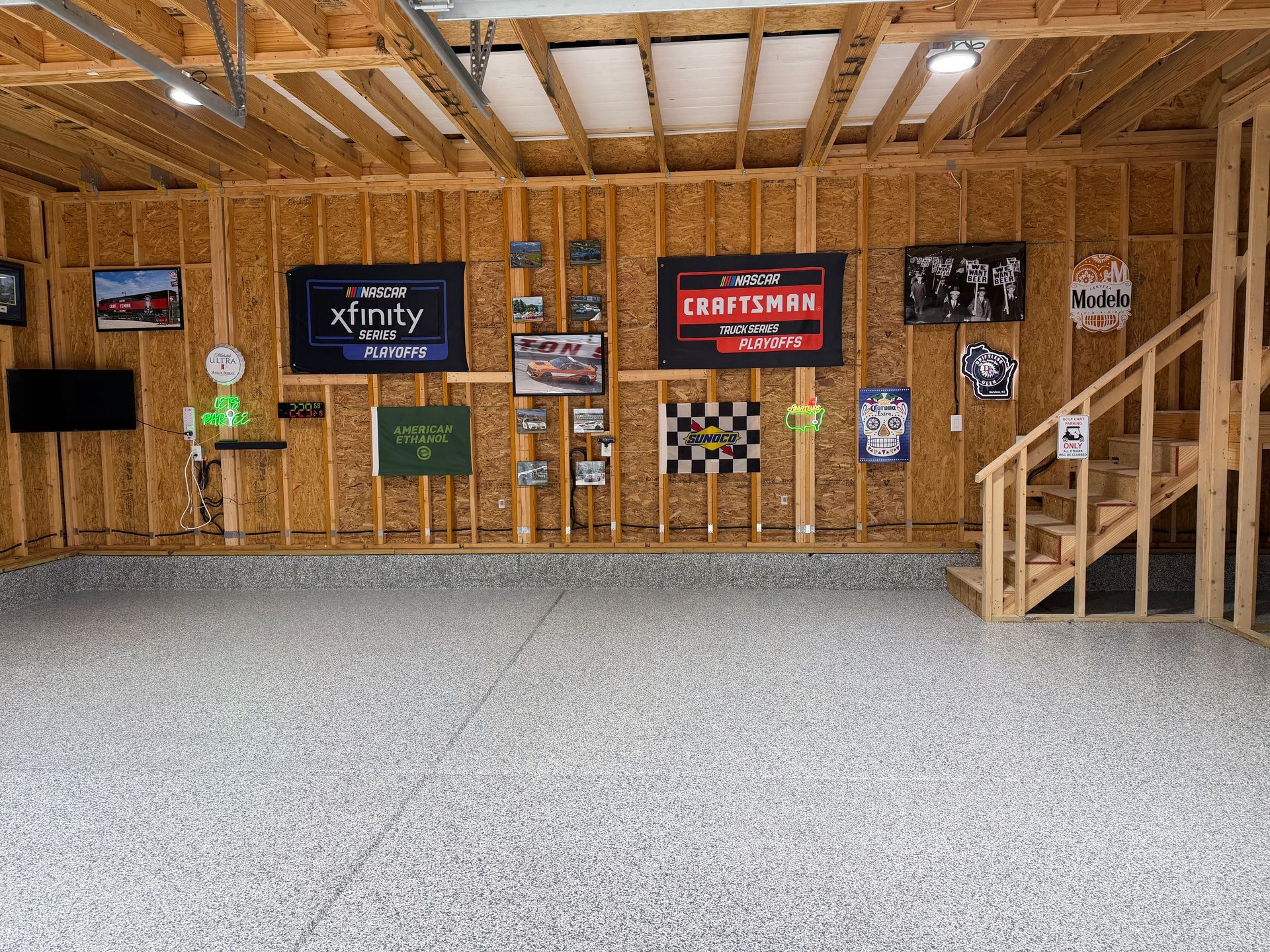 Wooden indoor sports hall with banners on the wall and a gravel floor under exposed beams.