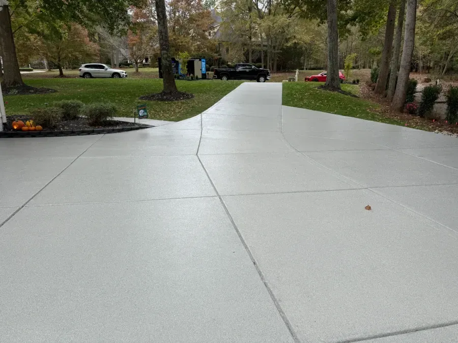 Tan building exterior with curved wall, small flower bed, and asphalt pathway.