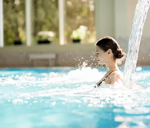 Water Pouring Down Behind A Womans Back In A Pool — Creative Pools and Spas in Melbourne, VIC