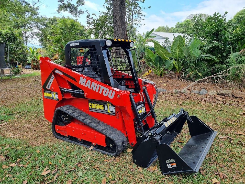 A red manitou skid steer loader is parked in the grass.