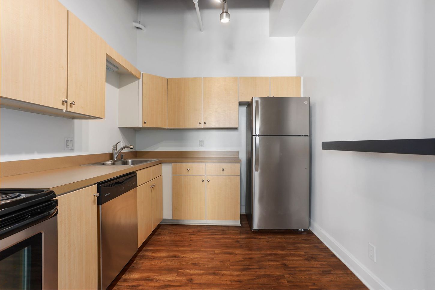 A kitchen with stainless steel appliances and wooden cabinets