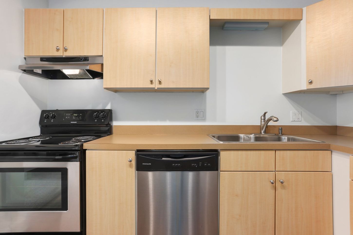 A kitchen with stainless steel appliances and wooden cabinets