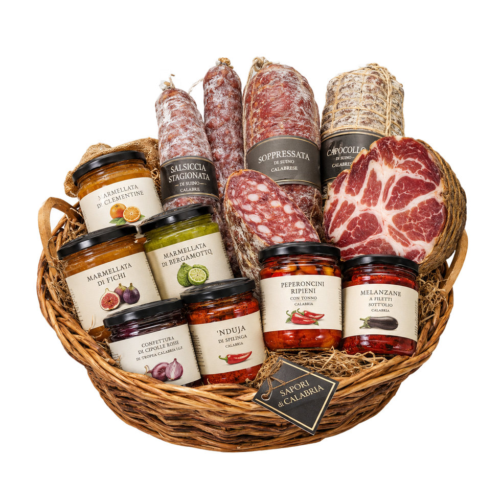 Cesto di vimini pieno di salumi assortiti, vasetti di creme spalmabili e formaggi su sfondo bianco.