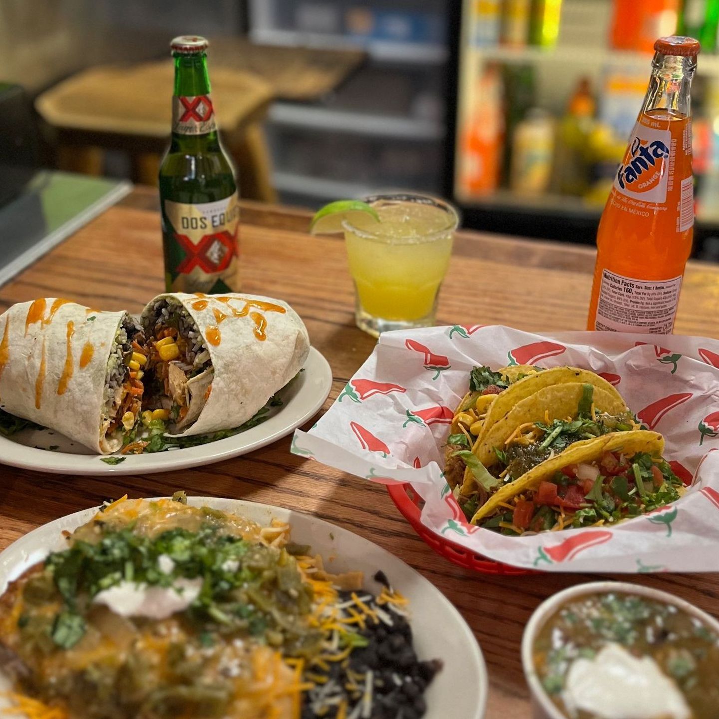 A table topped with plates of food and drinks including a bottle of fanta