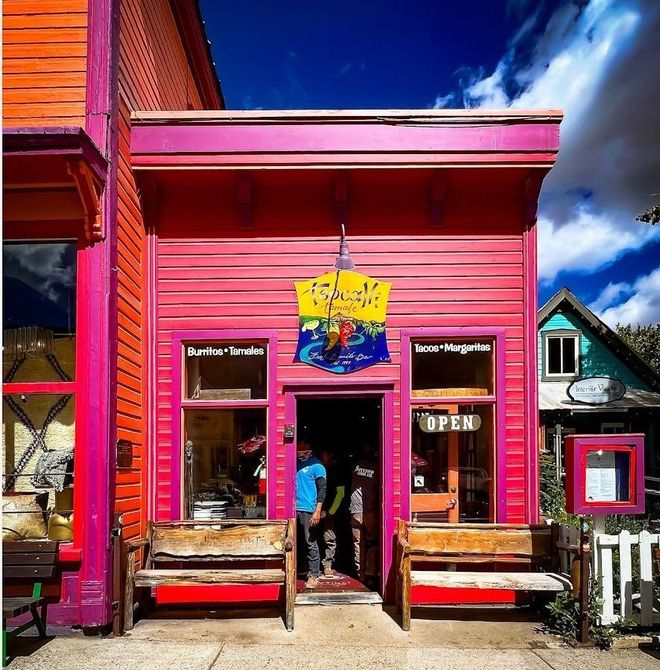 a brightly colored building with a sign that says open
