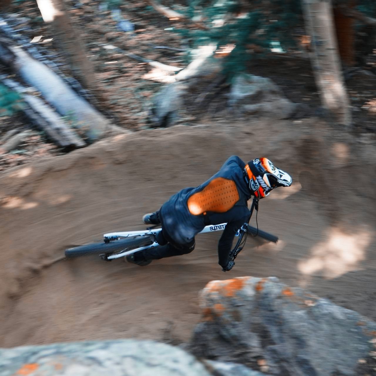 A person is riding a bike down a dirt path with a helmet on