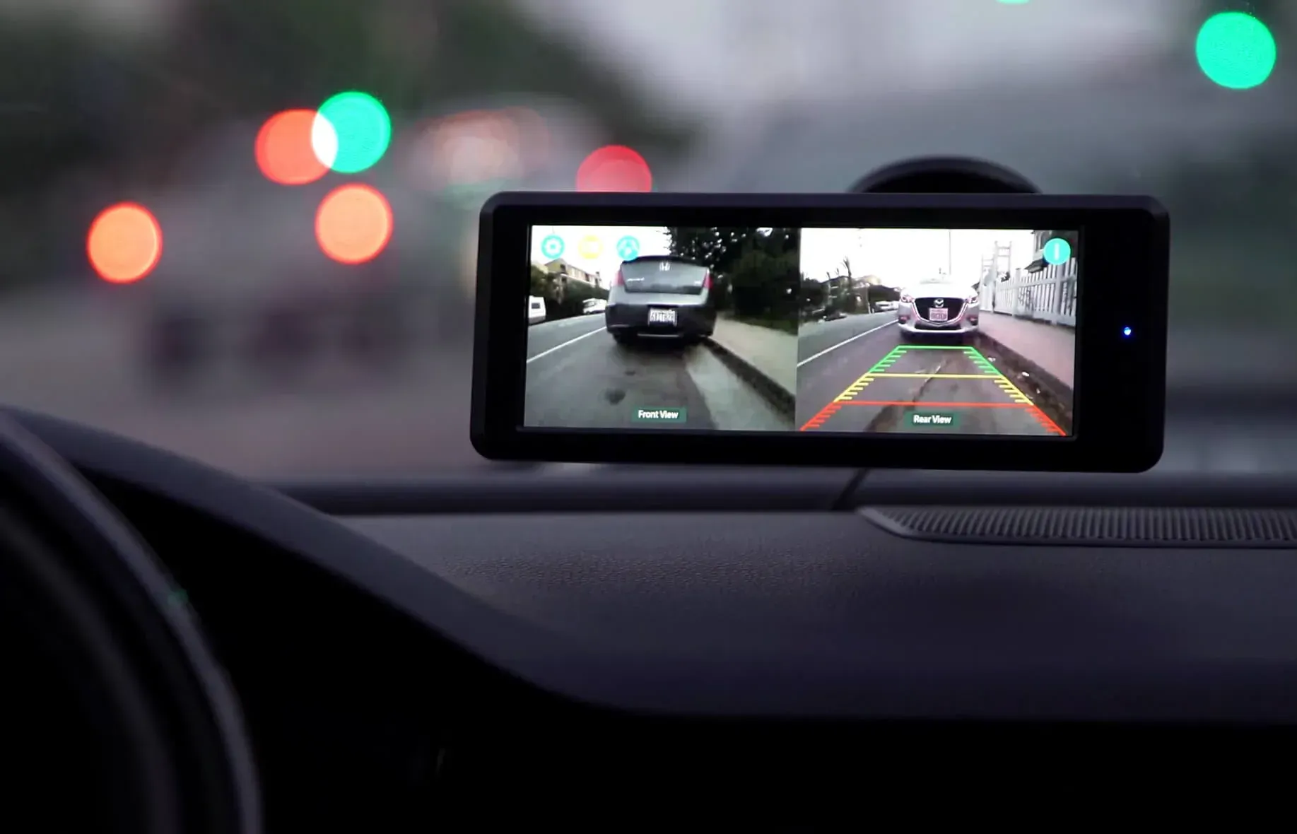 Dashboard display showing split-screen views of a vehicle's rear, with streetlights in background.