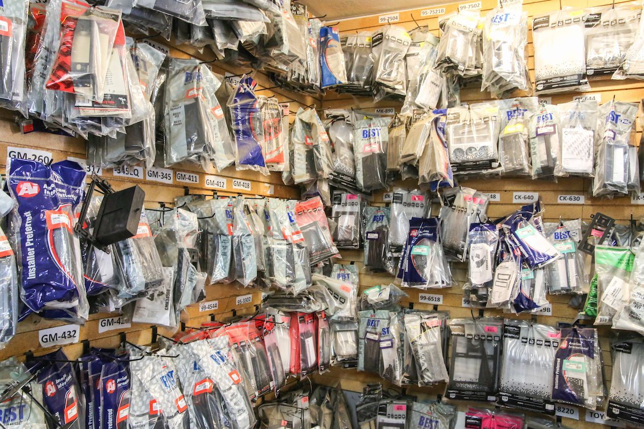 A wall in a shop packed with various packaged items, mostly in clear plastic, possibly for electronics.