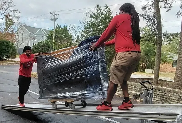 two men are carrying Furniture for a door to door delivery
