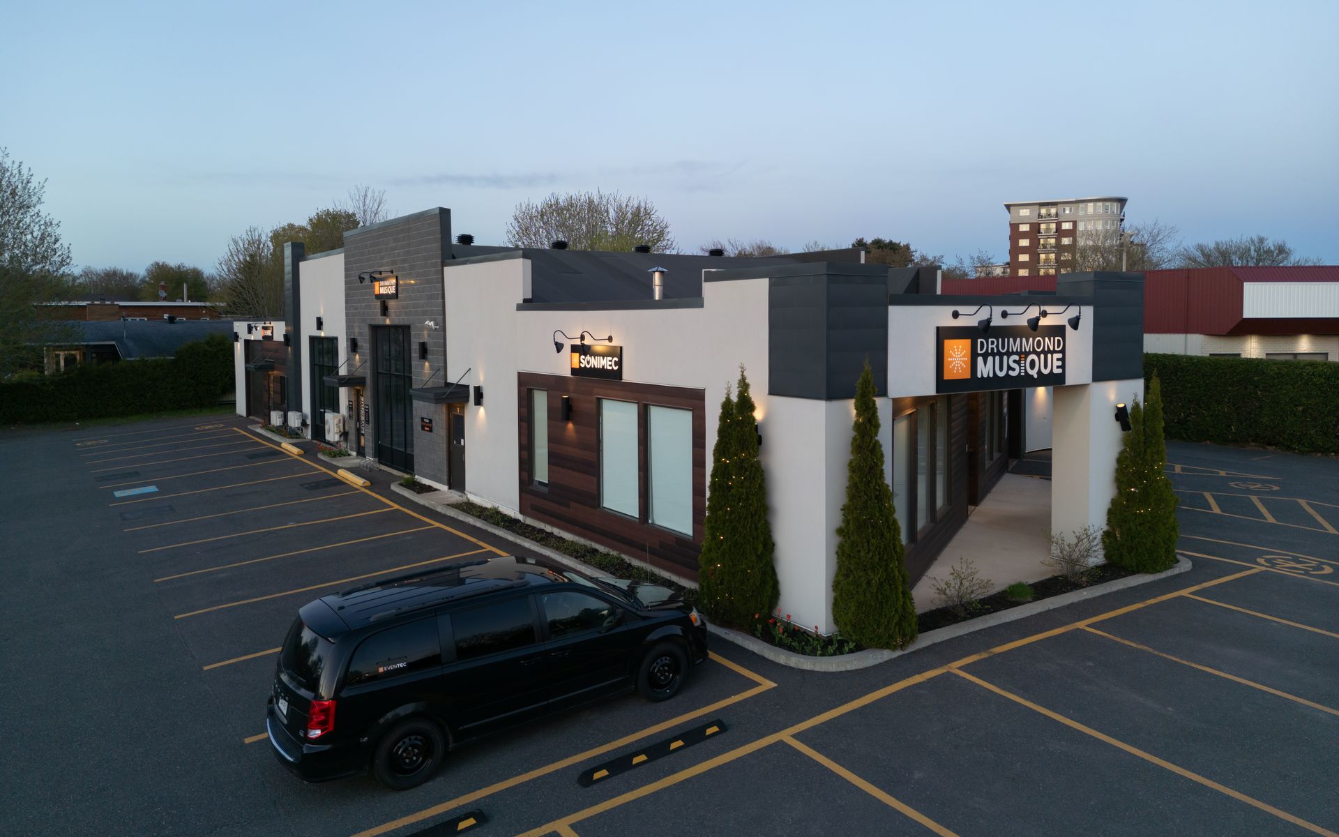 Immeuble de bureaux moderne avec une camionnette noire garée devant au crépuscule