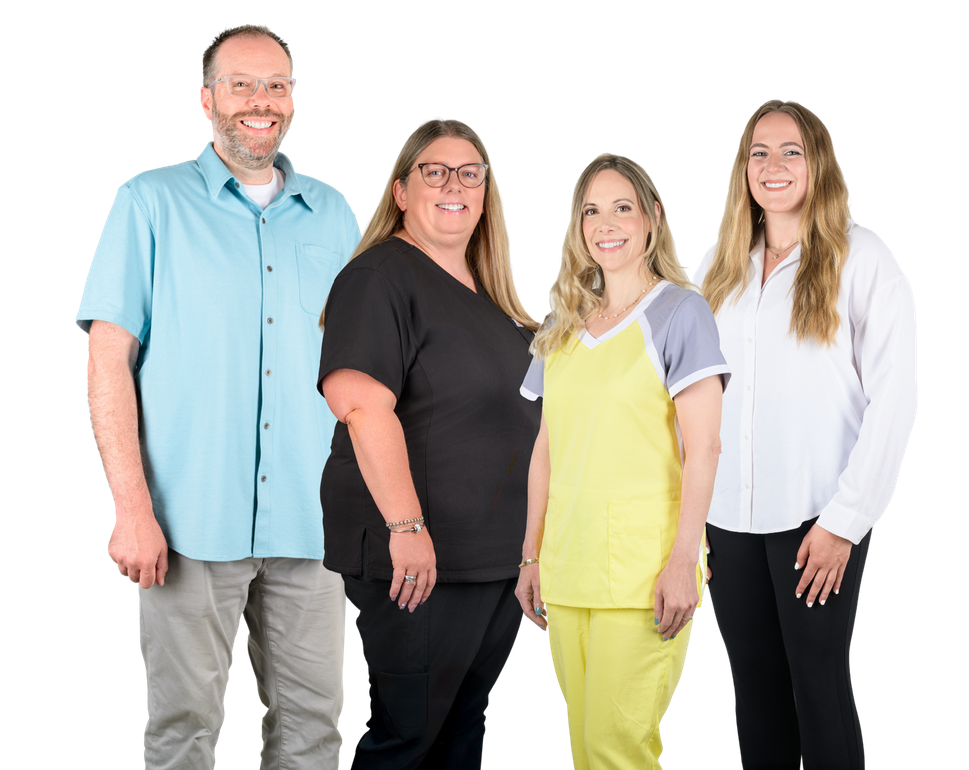 Four people smiling, standing together against a white background; one in a blue shirt, others in scrubs and a white blouse.