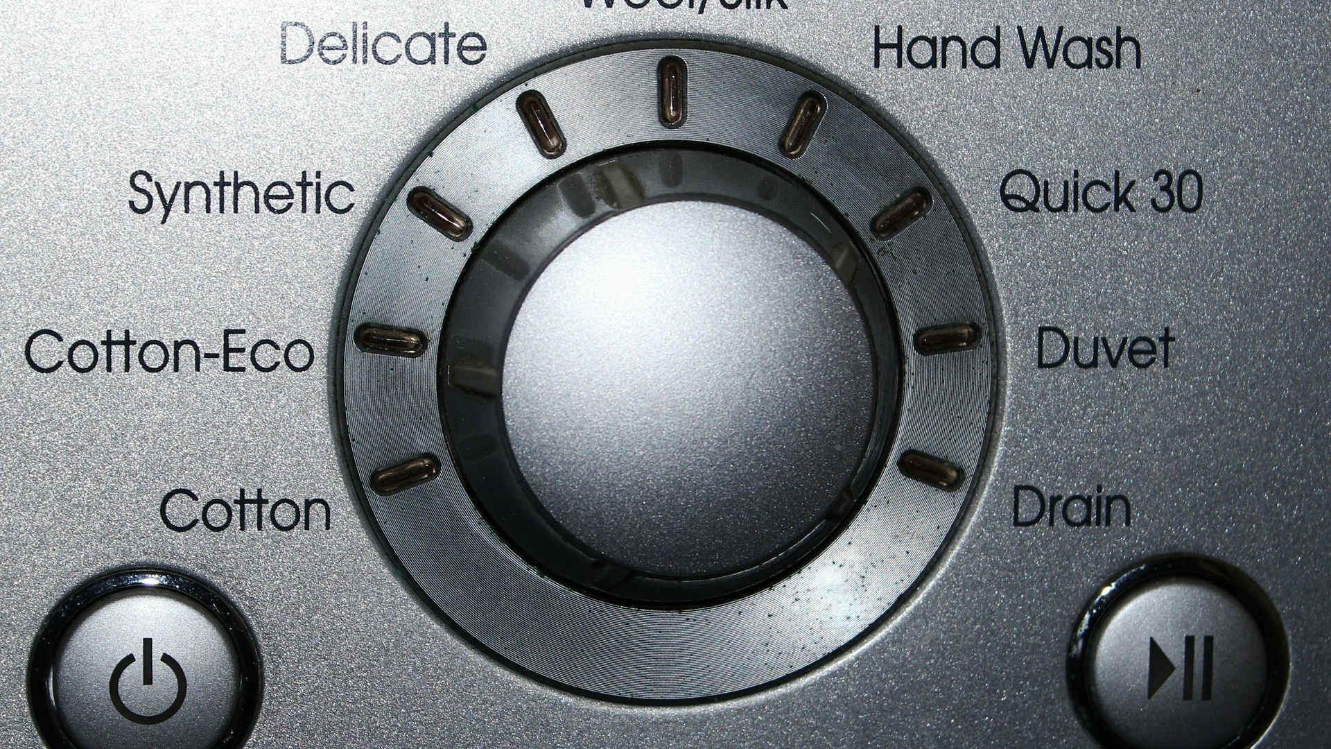 A close up of a washing machine 's synthetic button