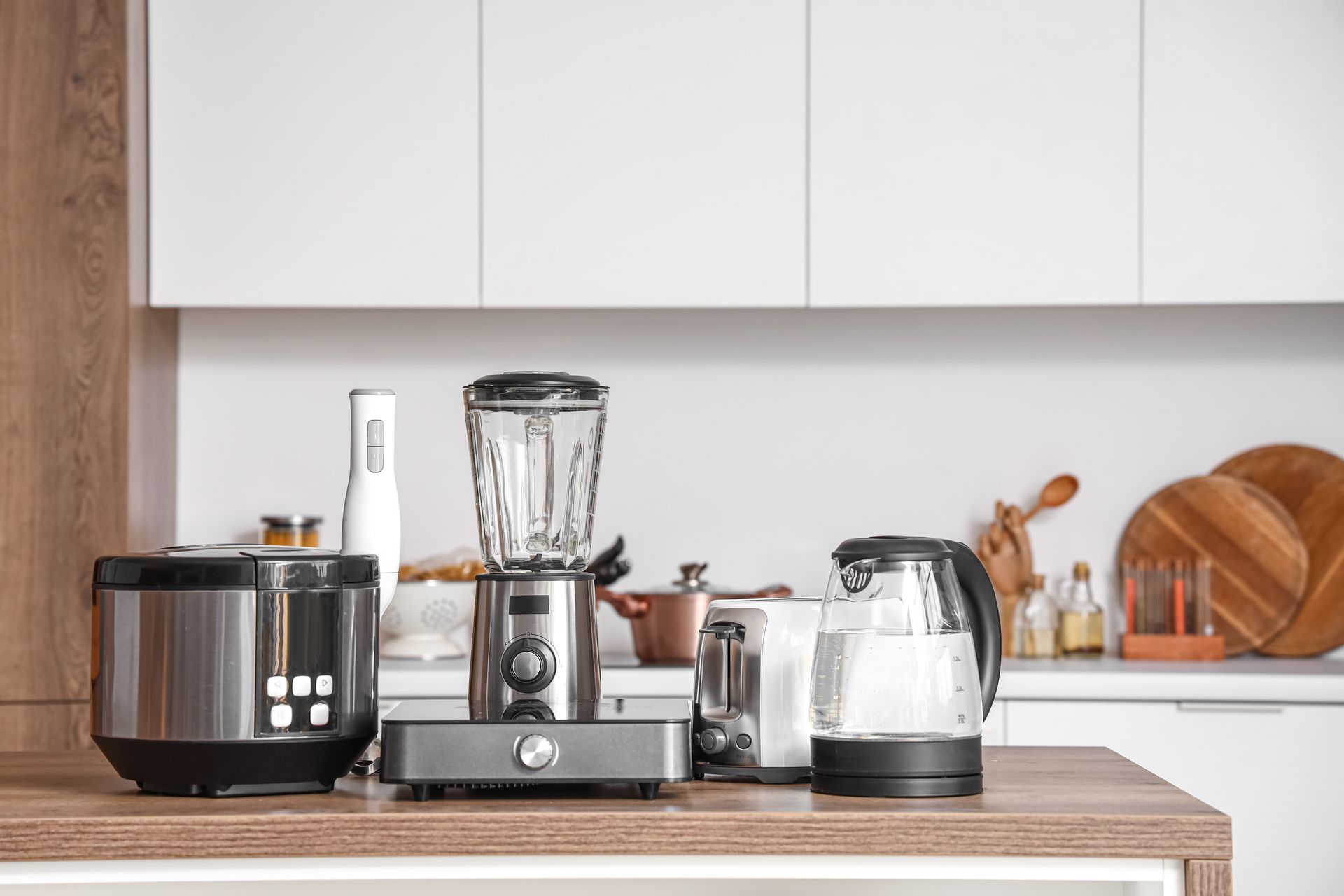 A bunch of kitchen appliances are sitting on a counter in a kitchen.