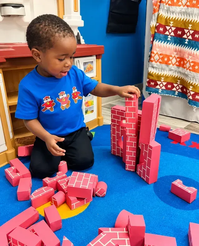 toddler playing with colorful building blocks in a daycare classroom