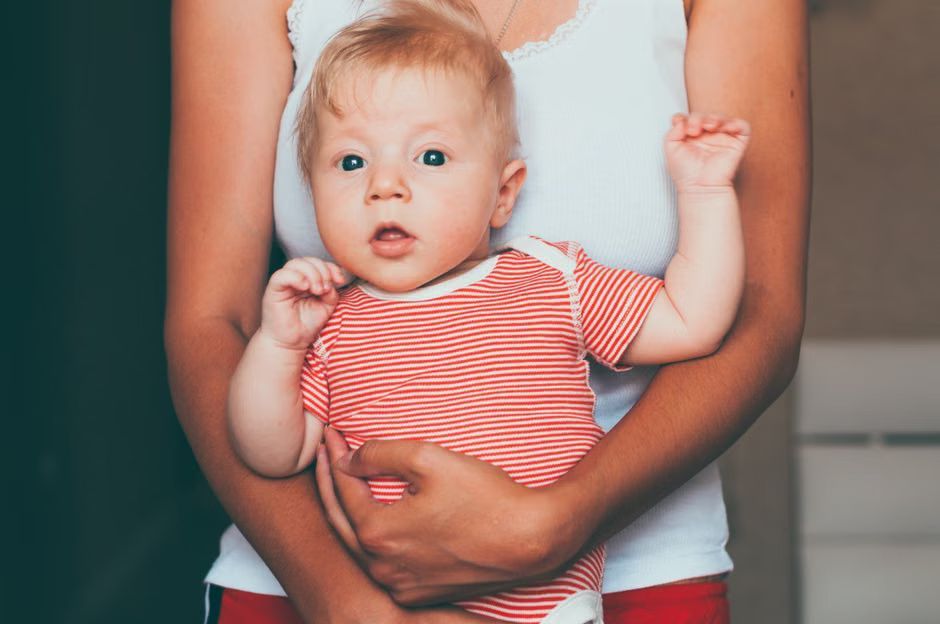 caregiver holding an infant in a cozy daycare nursery