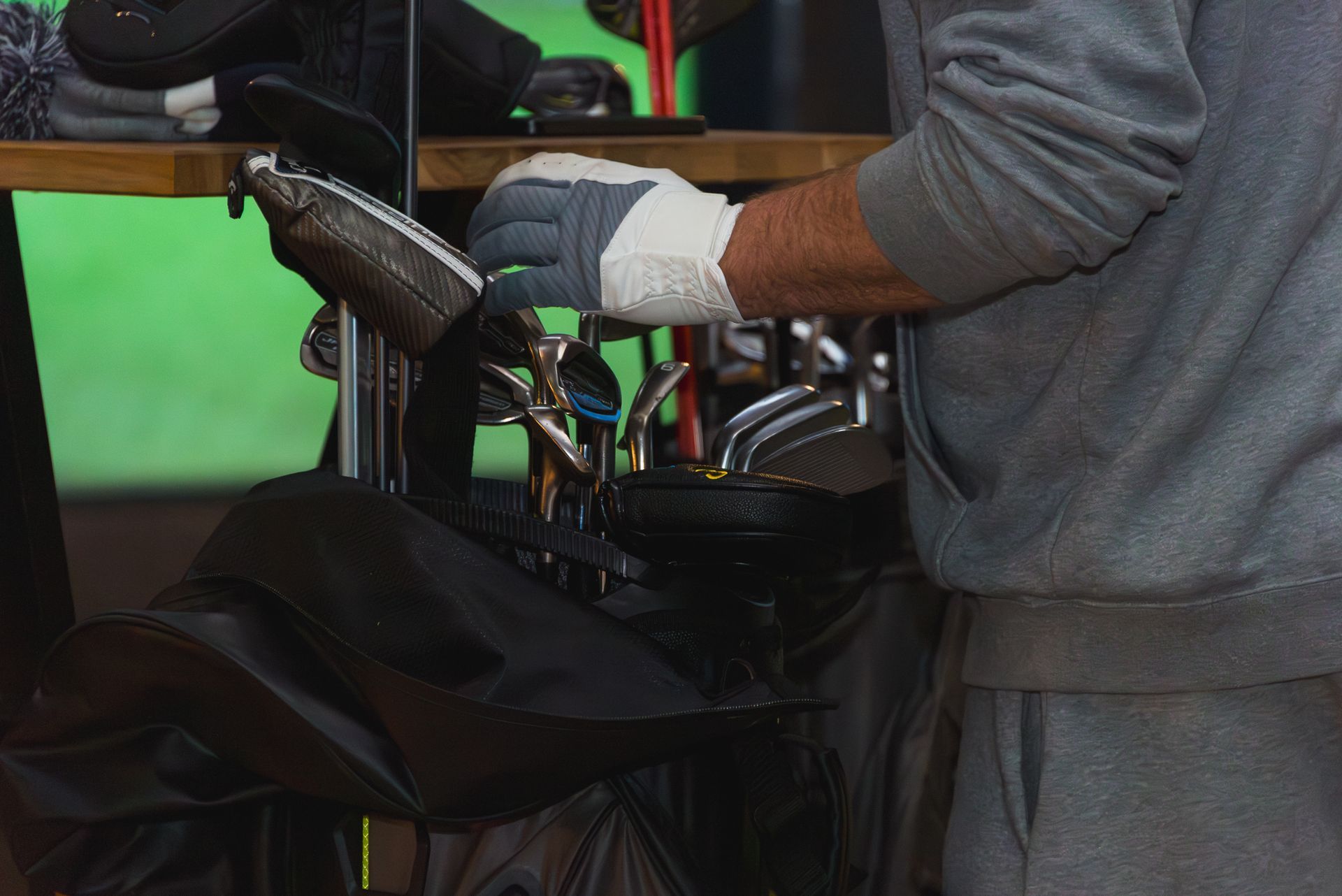 Gloved person handling equipment beside a bed or stretcher in a workshop or medical setting