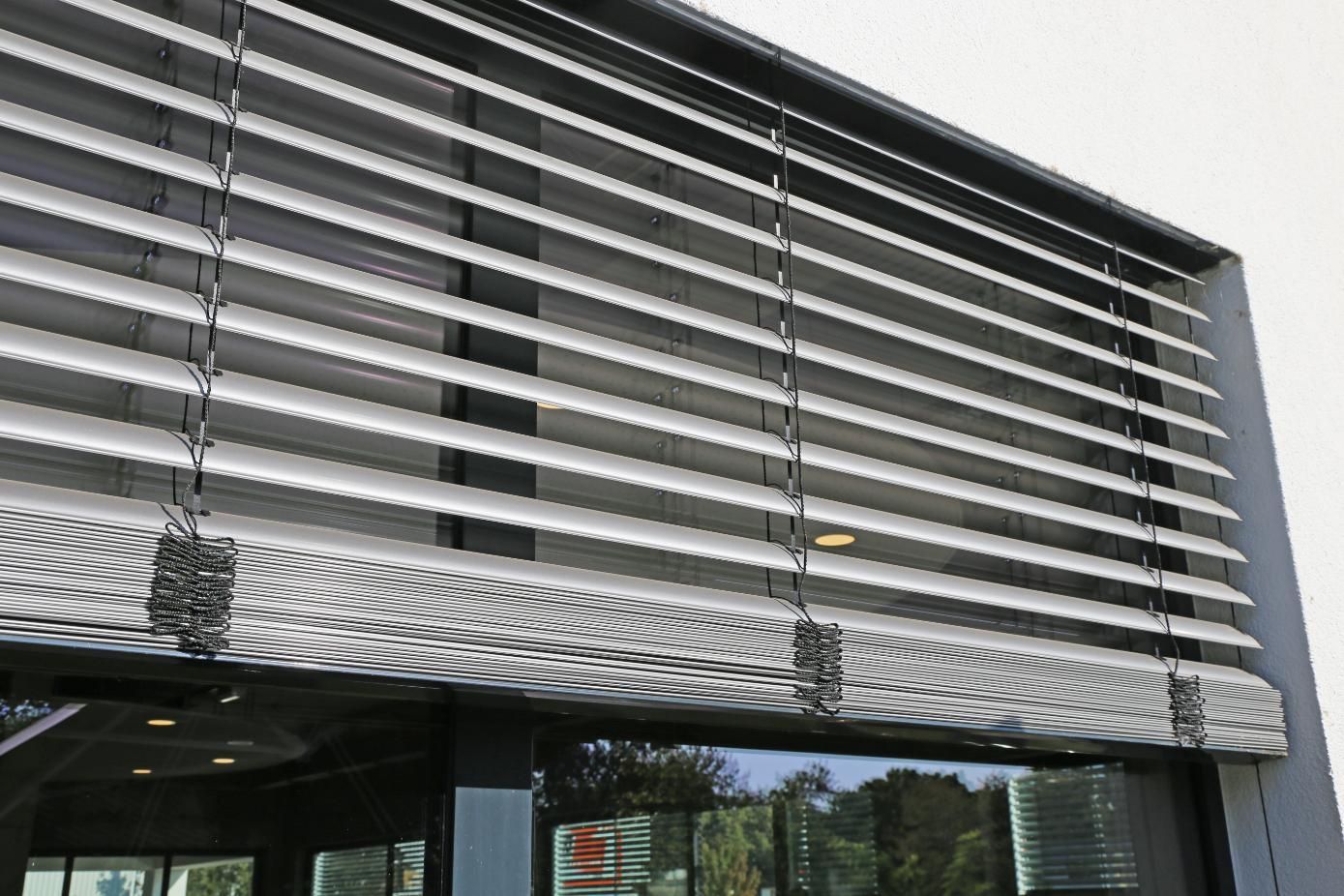 Modern building facade with horizontal metal louvers over large windows