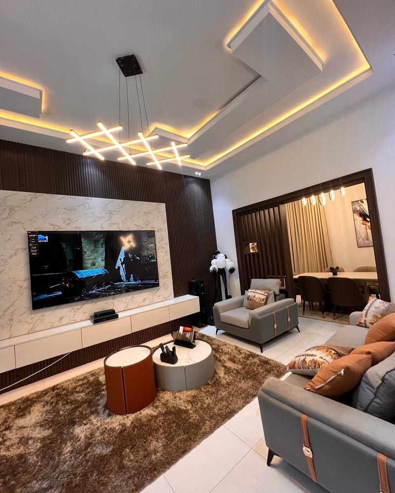 A living room with a couch , chair , table and television.