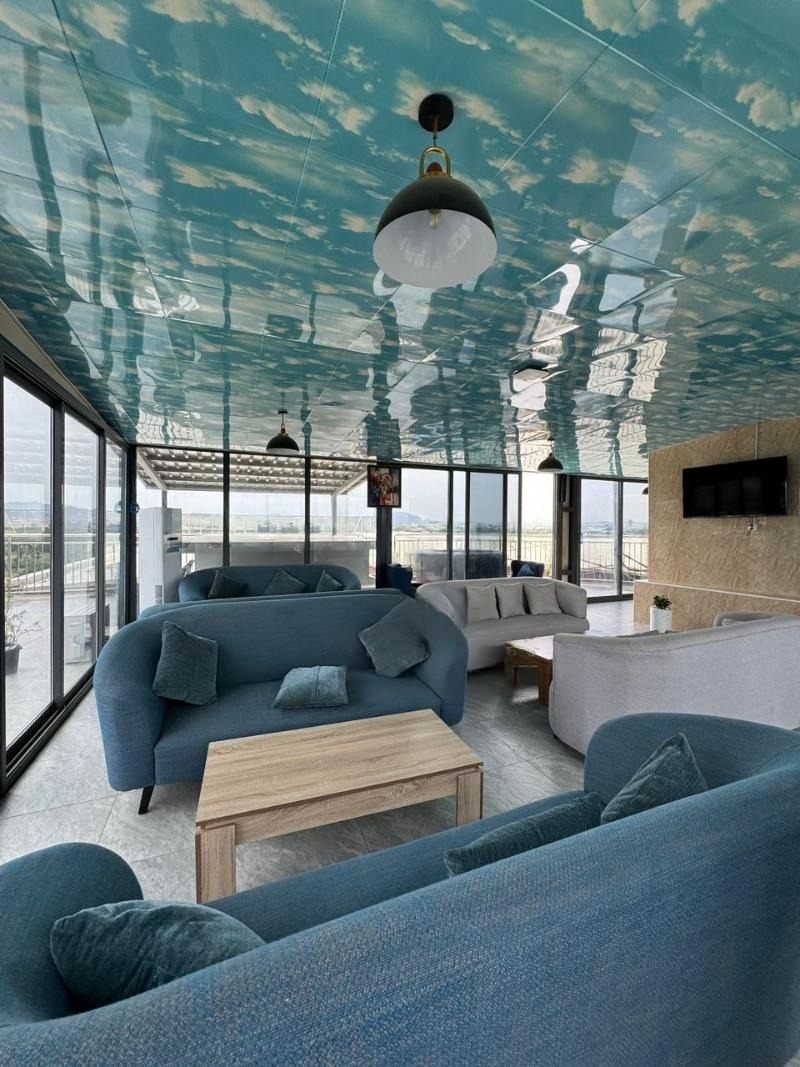 A living room with blue furniture and a blue ceiling